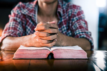 young man praying with a Bible 