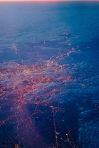 aerial view over streaks of light from a city below 