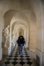 A woman standing in the halls of the Vatican 