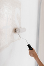 Paint being rolled on a wall.