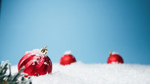 Red Christmas balls in a snowy background