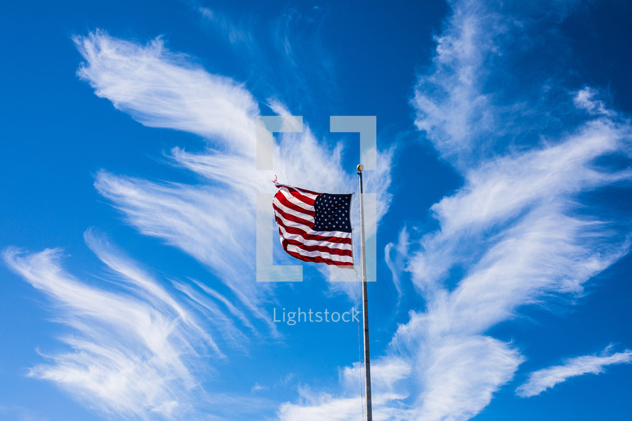 American flag on a flagpole against a blue sky 