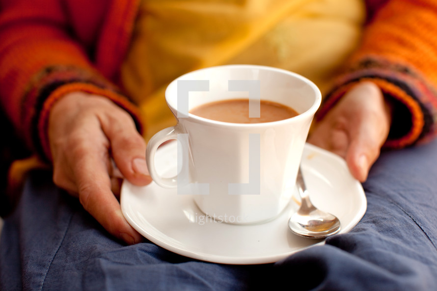 a woman in India holding a cup of tea 