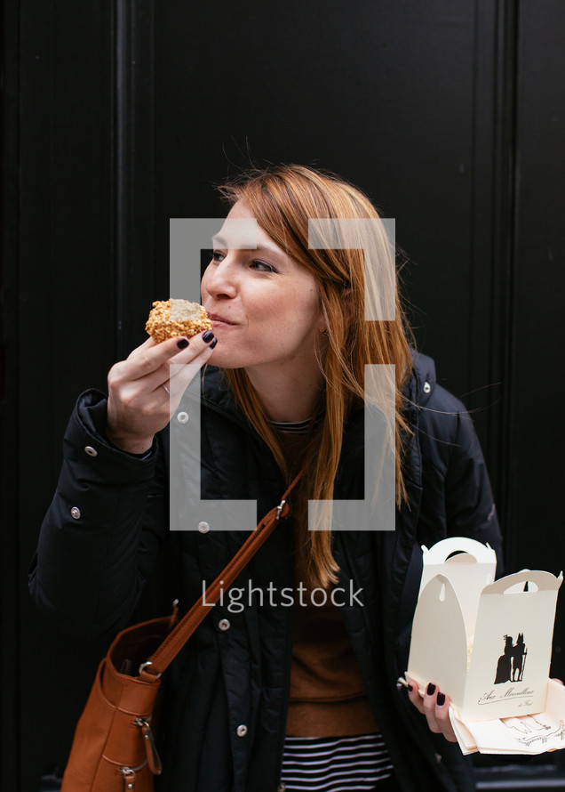 a woman taking a bite out of a muffin 