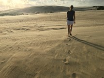 A woman walking in the sand 
