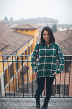 A woman in a green shirt smiling on a patio