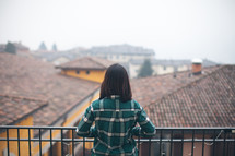 A woman in a green shirt looking out over a city