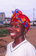 a smiling girl wearing a scarf on her head 
