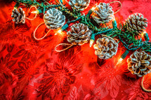 Christmas lights, pine cones and red table cloth