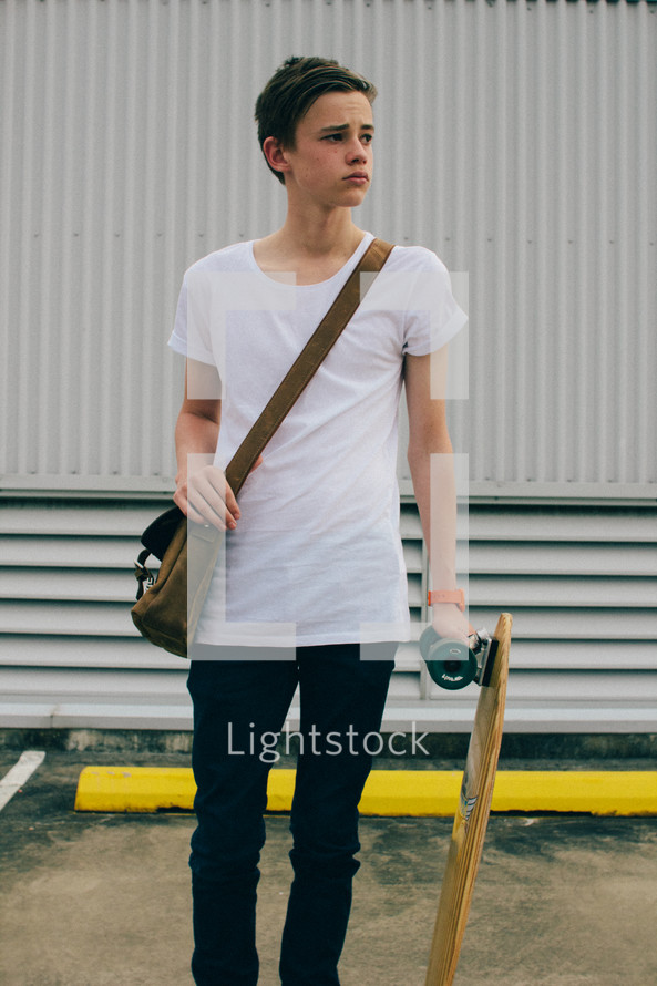 man with a leather satchel and skateboard 