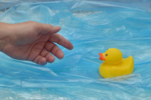 Concept Pollution Plastic In Sea with Yellow Rubber Duck Toy and Man Hand