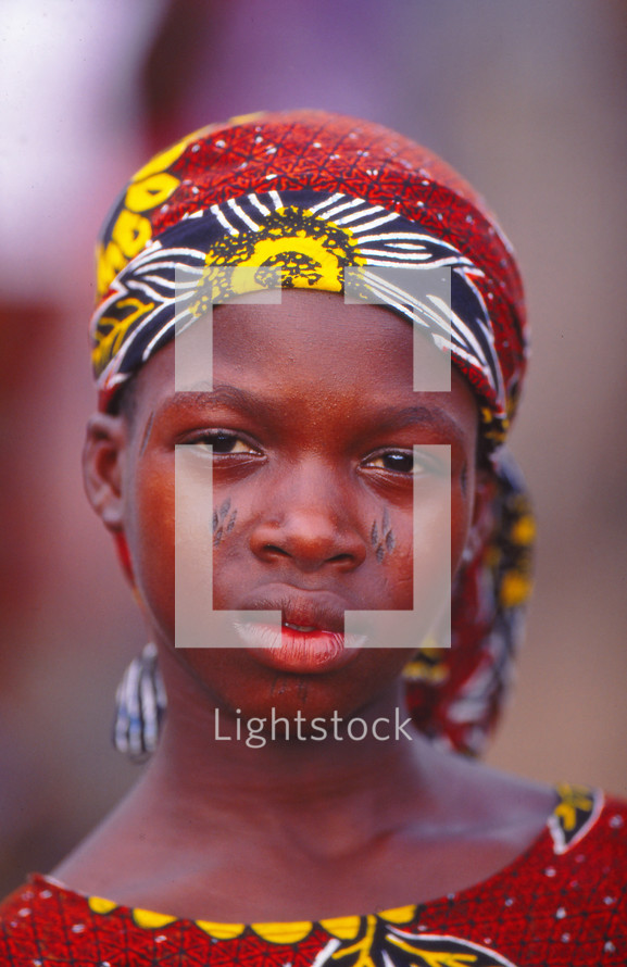 a girl child in traditional clothing with tribal face markings