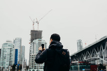 a man taking pictures of a city 