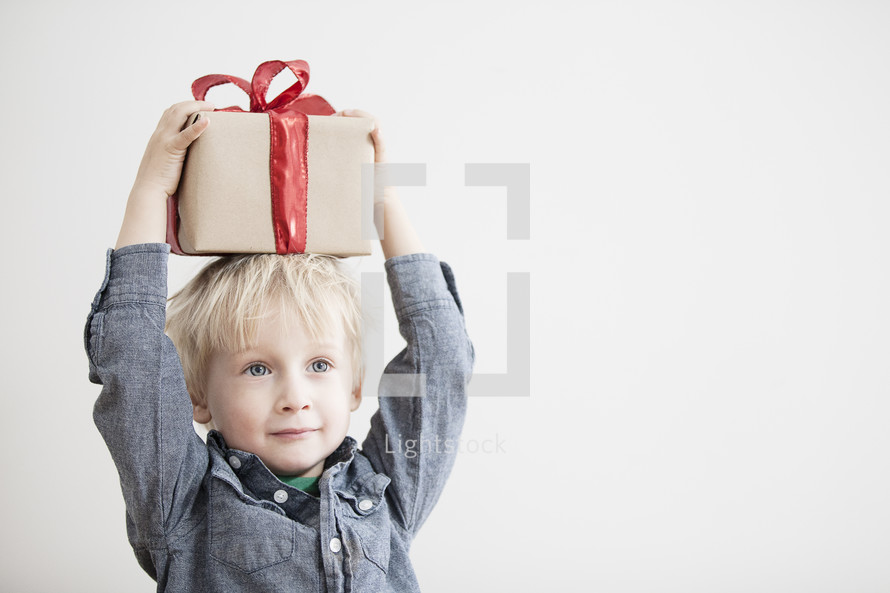 A child holding a Christmas gift. 