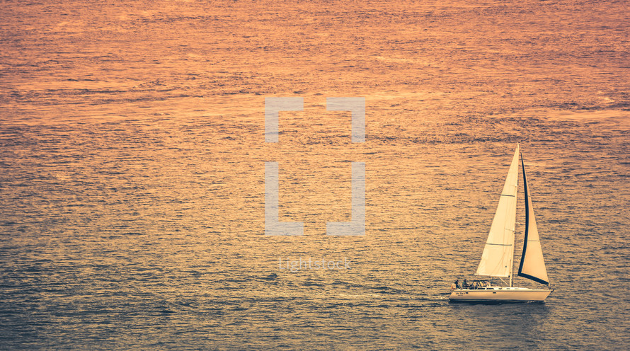sailboat in the ocean at sunset 