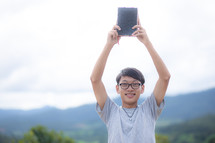 a young man holding up a BIble 