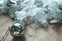 bell and white Christmas greenery on a wood background 