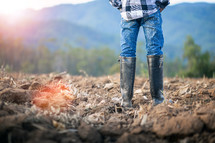 man with rubber boots farming 