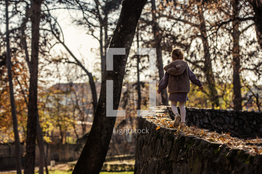 a child running in fall leaves 