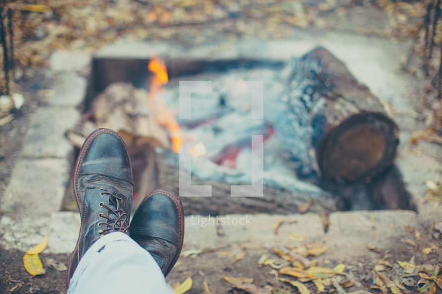feet resting by a fire pit 