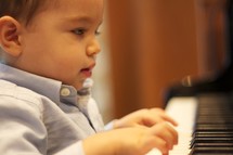 toddler boy playing the piano 