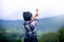 a child holding a cross 