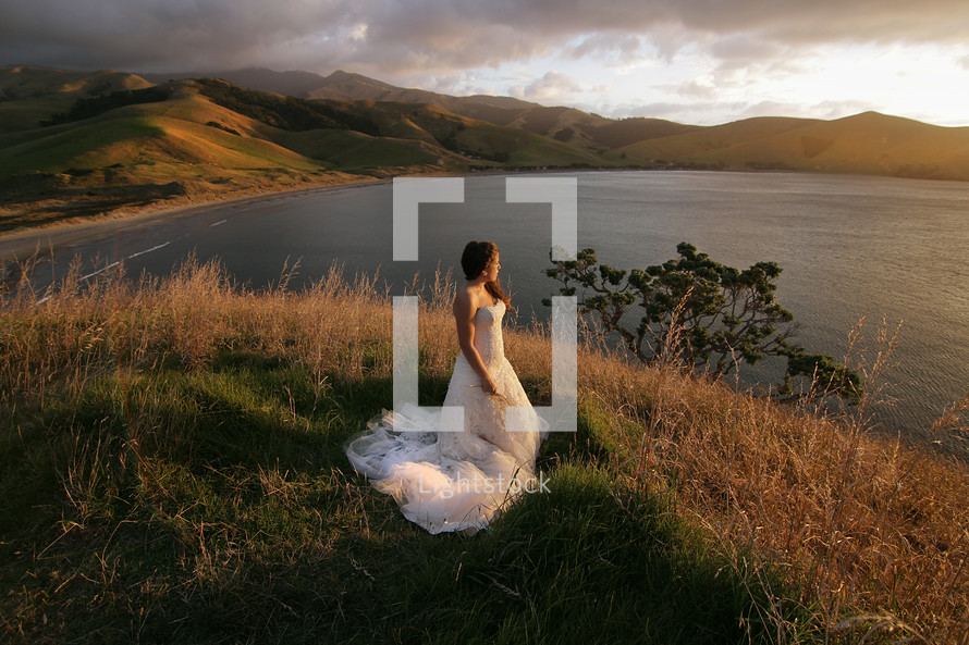 bride standing by a lake 