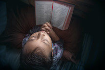 a child praying in bed 