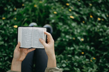 a girl reading a pocket Bible 