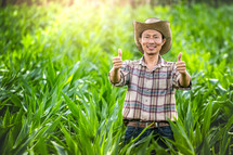 a farmer in a corn field giving a thumbs up 