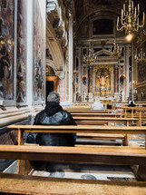 A Man Praying Inside An Old Church 