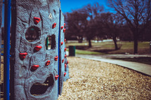 grips on a climbing wall at a playground 
