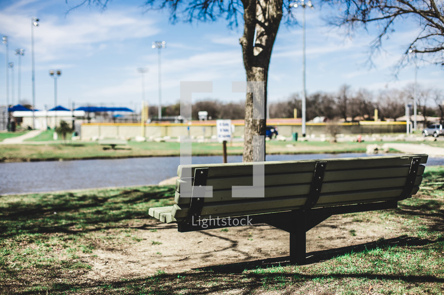 park bench with a view of a ballpark 