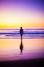 woman walking on a beach at sunset 