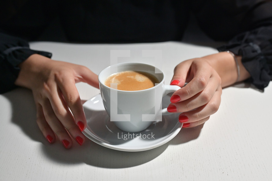 Young Woman with Cup of Coffee and Red Nail Polish