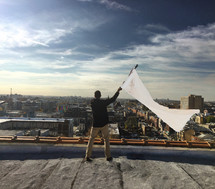 A man on a rooftop waving a white flag.