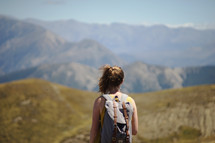 a woman backpacking through a mountain landscape 