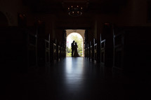 silhouette of a bride and groom in the doorway of a church 