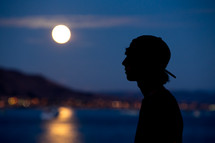 silhouette of a teen boy under moonlight 