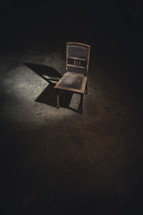 an old chair in a dark room 