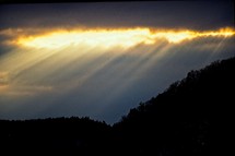 sunbeams through the clouds over mountains 