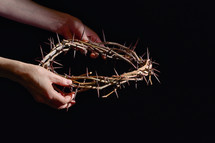 hands holding out a crown of thorns 