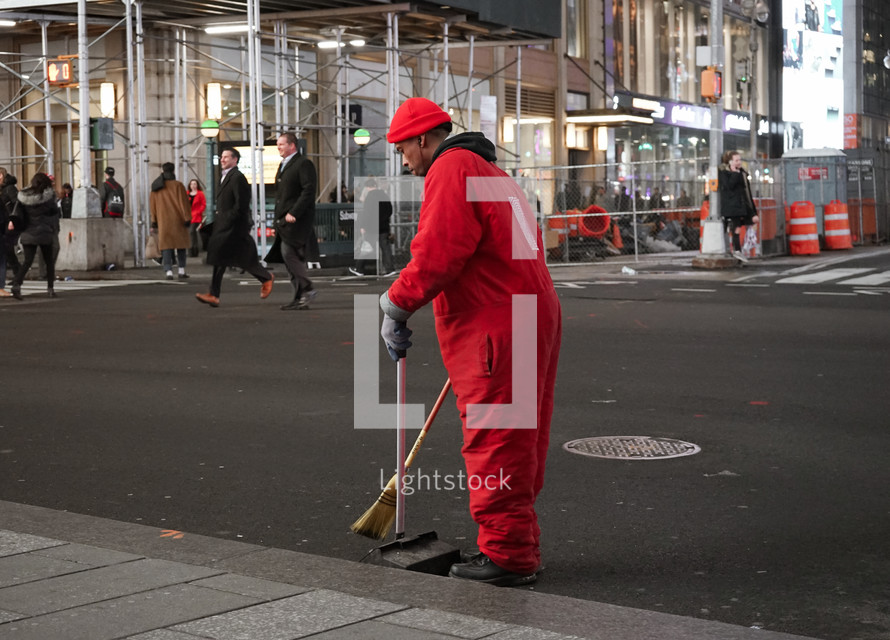 a man sweeping a road 