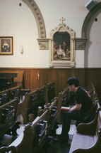 A man praying the Stations of the Cross in a Catholic church