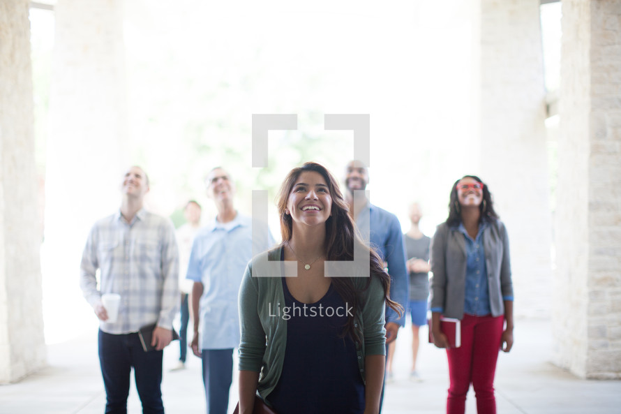group of people looking up to God holding Bibles 