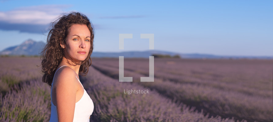 a woman walking in a field of lavender 