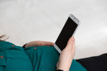 a pregnant woman looking at a cellphone 
