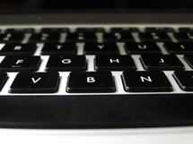 Close-up of space bar and letter keys on silver keyboard