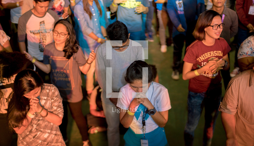people praying at a concert 
