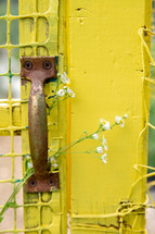handle on a yellow gate door 